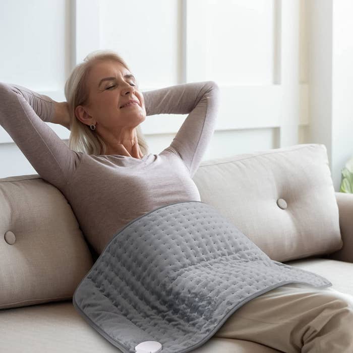 a person wearing the heating pad on their stomach