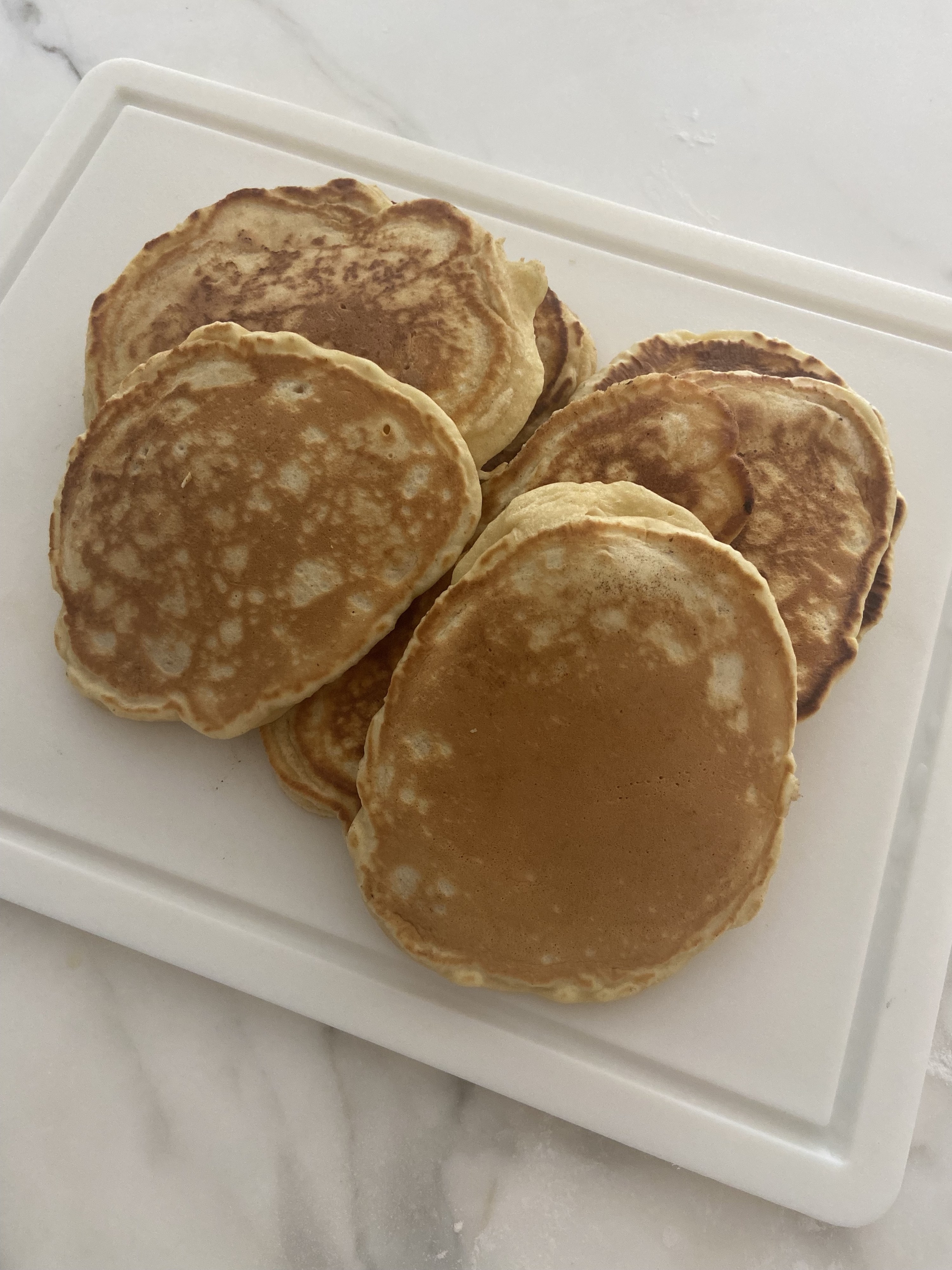 A stack of several pancakes that look similar to the third one pictured above