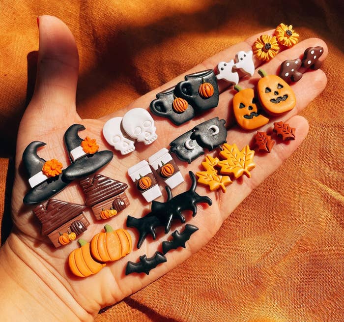 palm with small clay earrings in various Halloween motif shapes