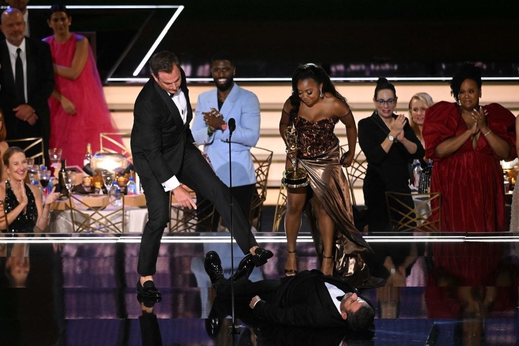 Jimmy Kimmel lying on the ground while others like Quinta Brunson look at him