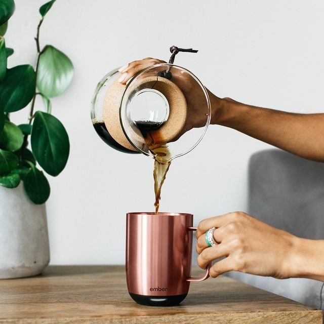 a model pouring coffee in the rose gold mug