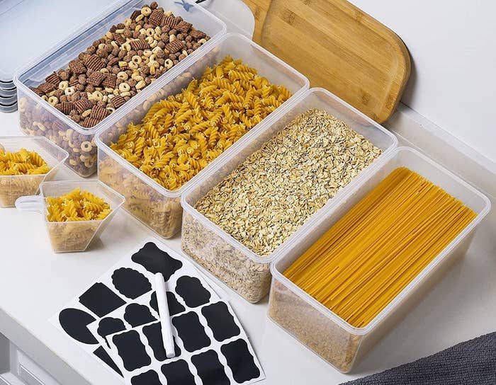 a set of long storage containers filled with pasta noodles, snacks, and oatmeal