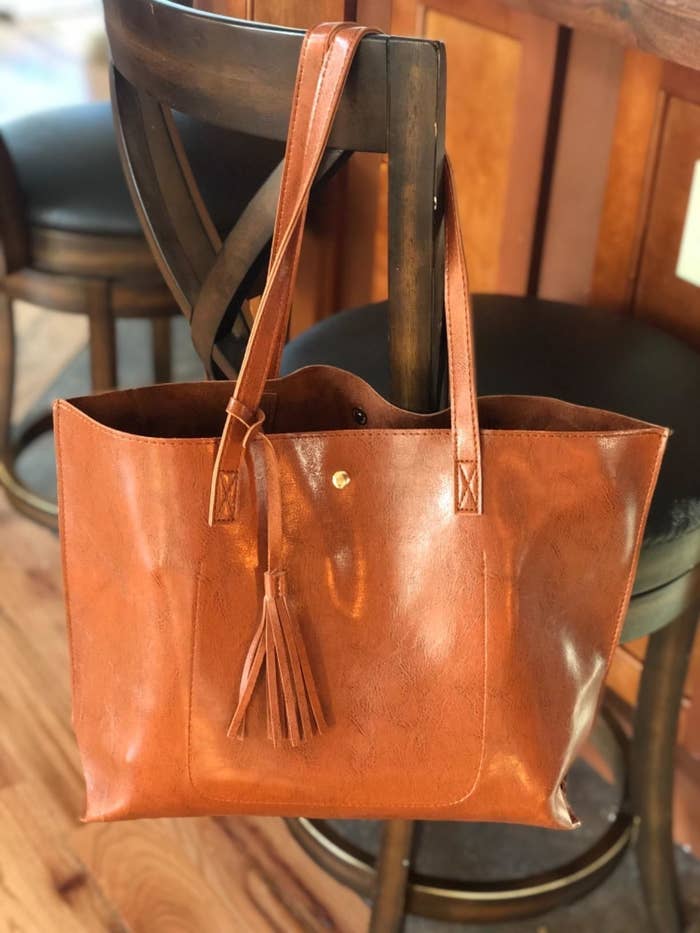 Reviewer image of brown tote bag with tassel hanging on a barstool