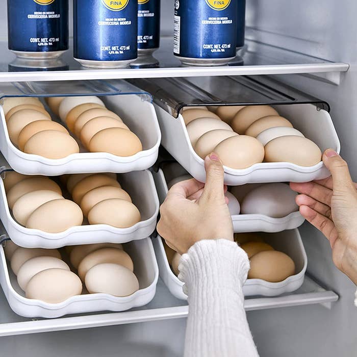 a person taking an egg out of the roll-out tray
