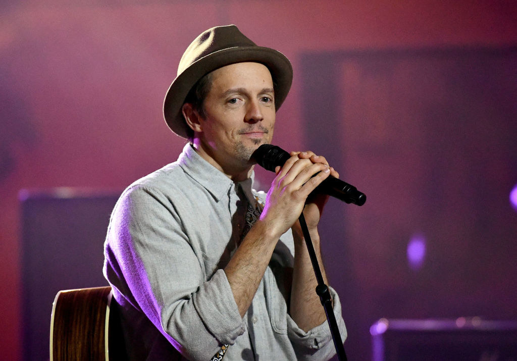 Jason in a hat at a microphone