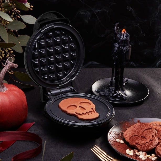 a mini skull waffle maker on a spooky breakfast table