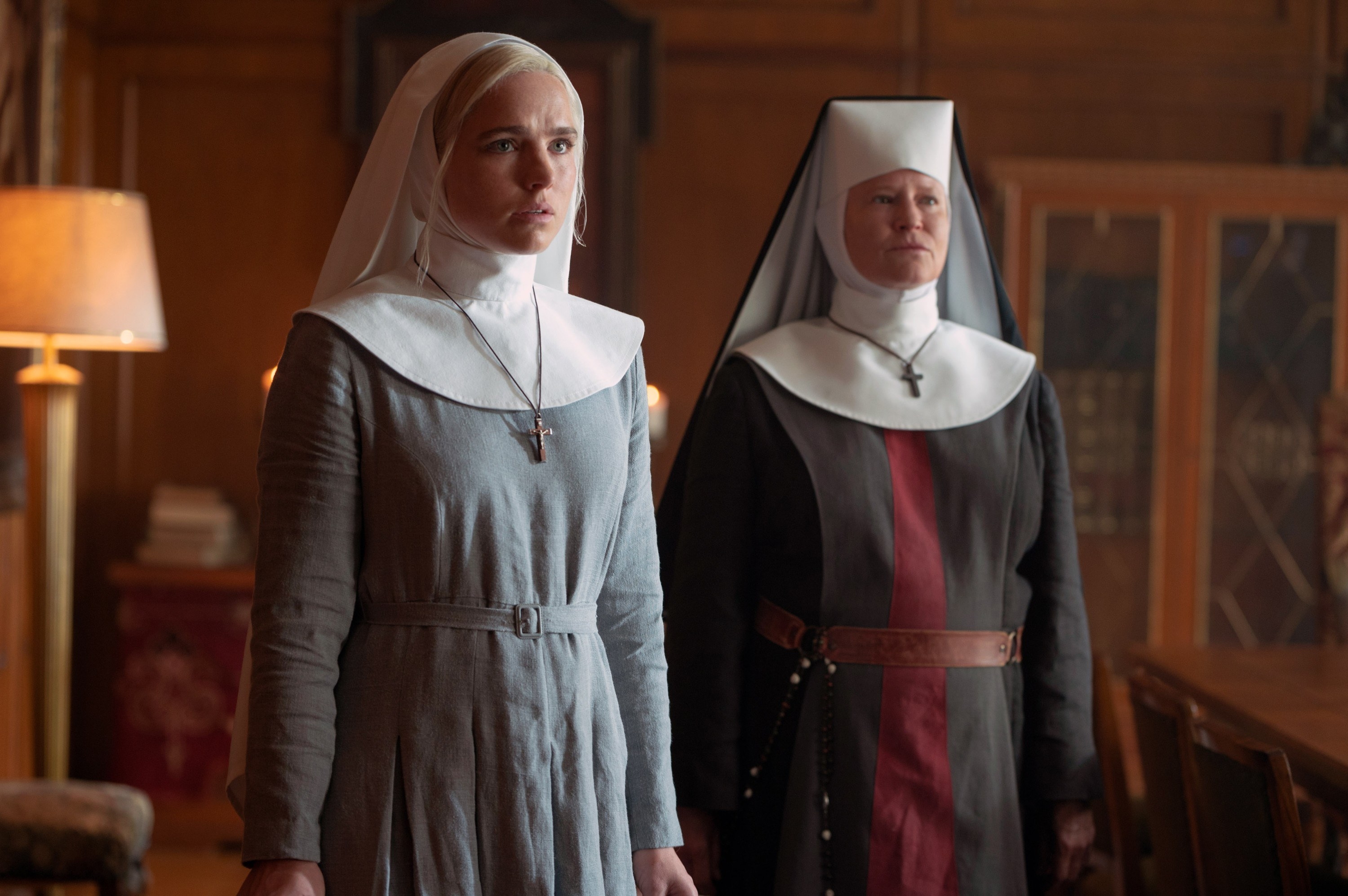 Two nuns stand in an office, looking worried