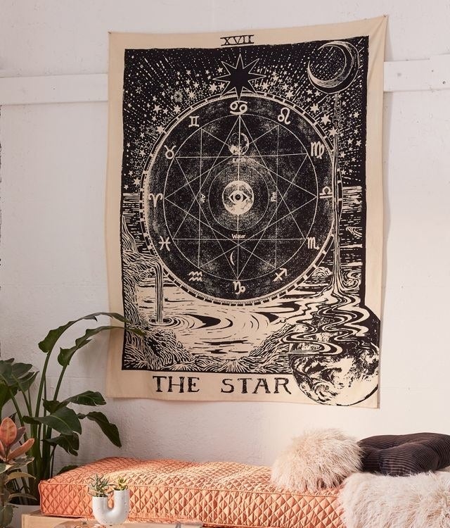 a tarot-inspired wall tapestry in a living room