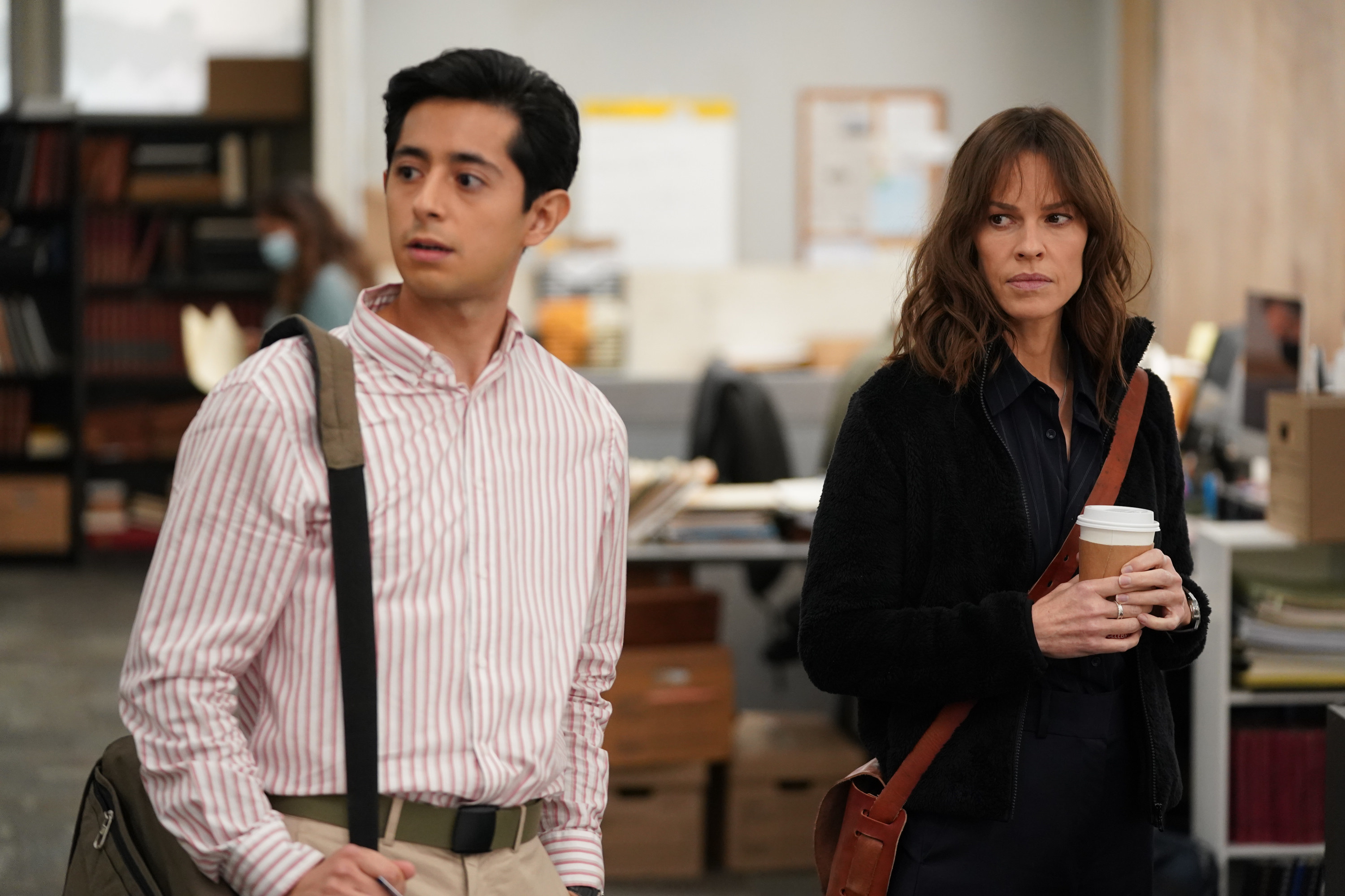 a man and a woman looking at something in an office