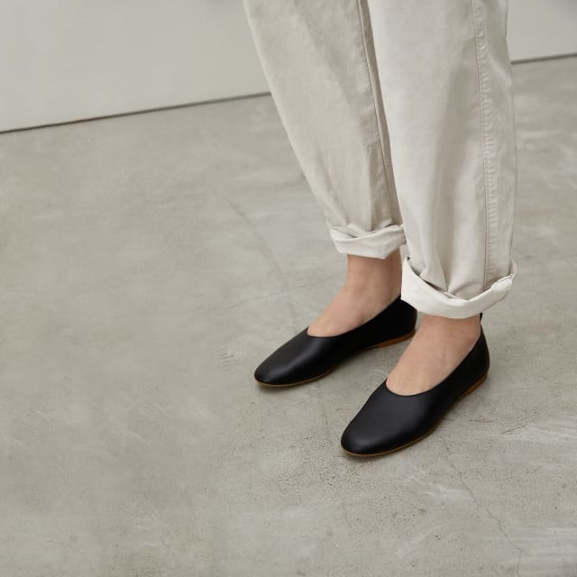 Model wearing the flats in black showing off the rounded toe