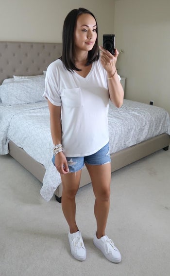 Reviewer wearing white tee with denim shorts