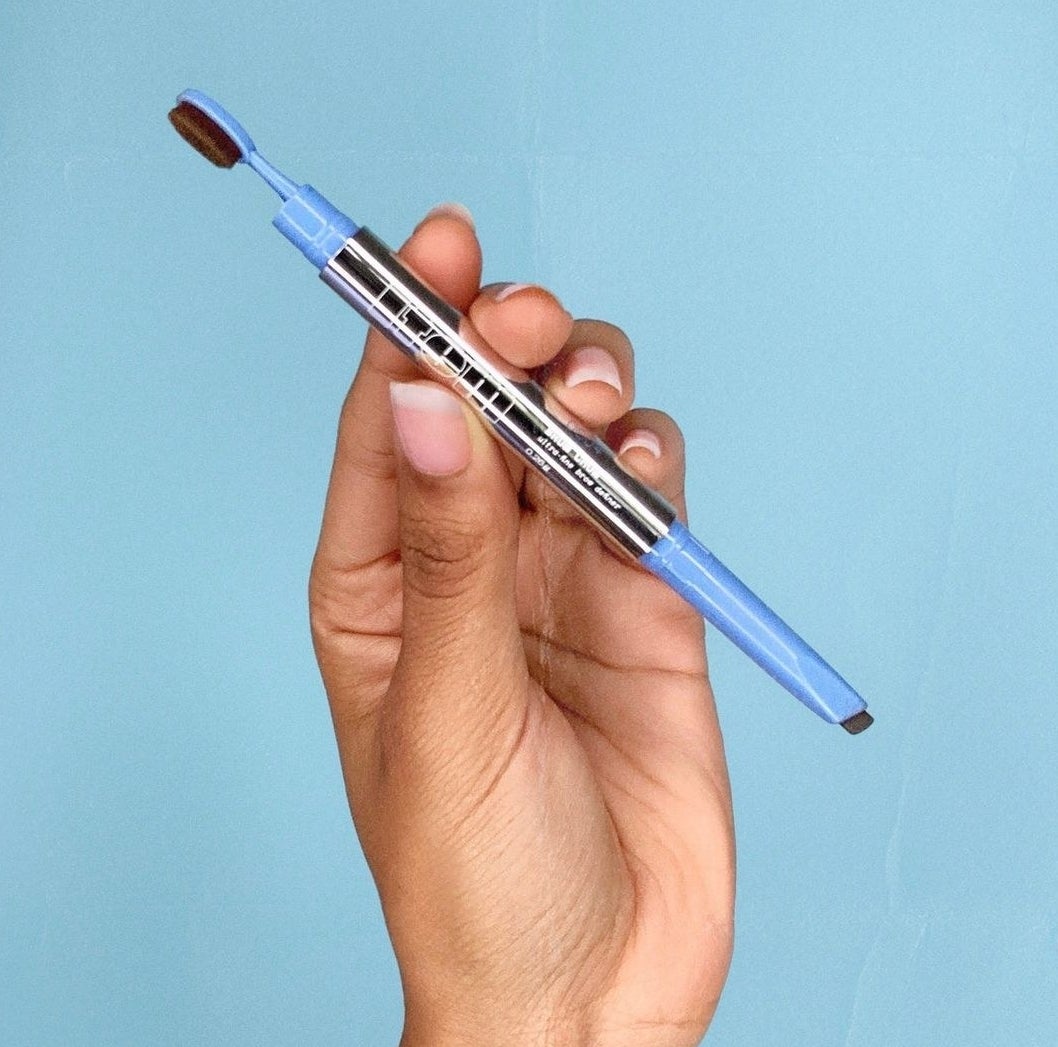 A person holding the brow pencil