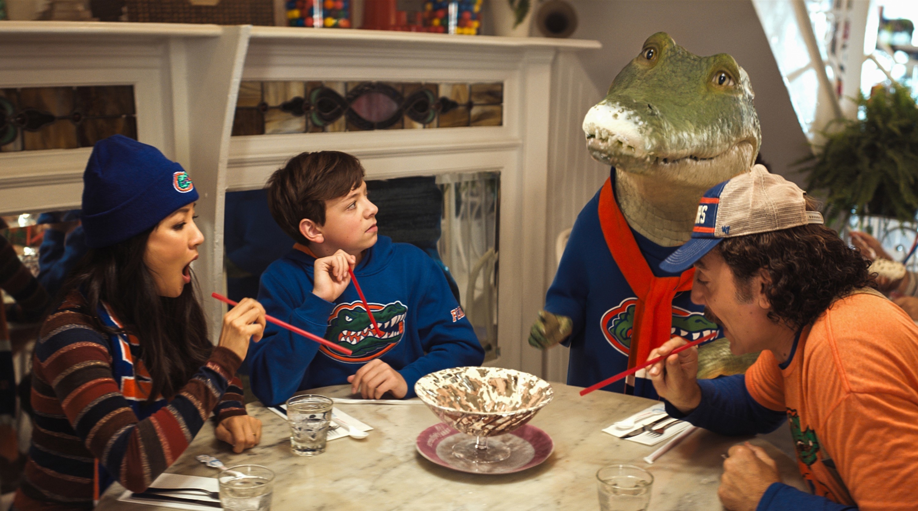 A family sitting at a dinner table with a talking crocodile