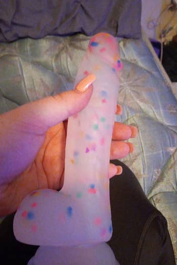 Reviewer holding confetti dildo