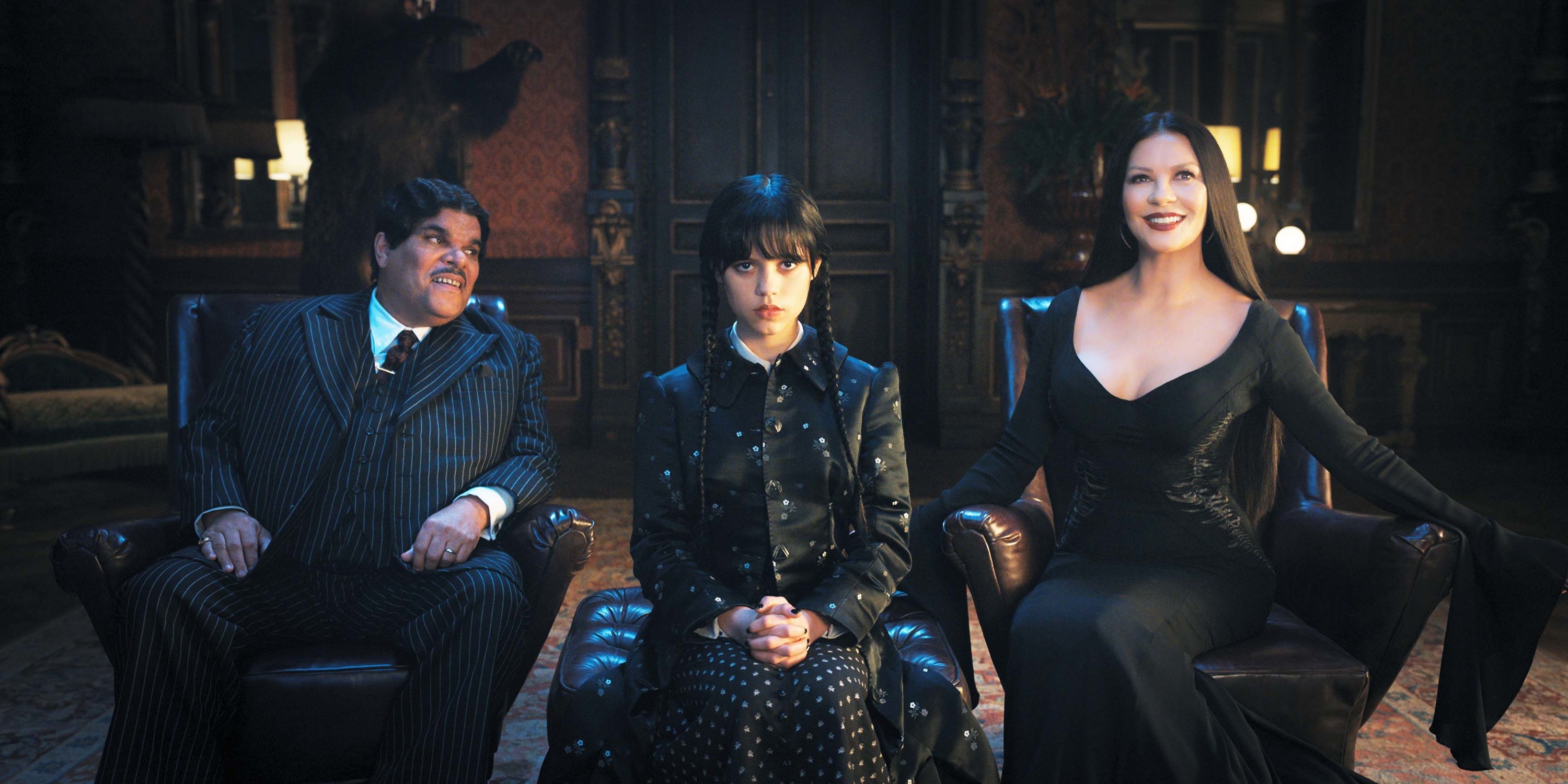 members of the Addams family sitting together with Wednesday in the middle