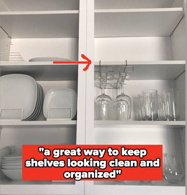 Inside of a cabinet with white dishes on one side and glassware on the other, including mounted wine glasses, with the caption 