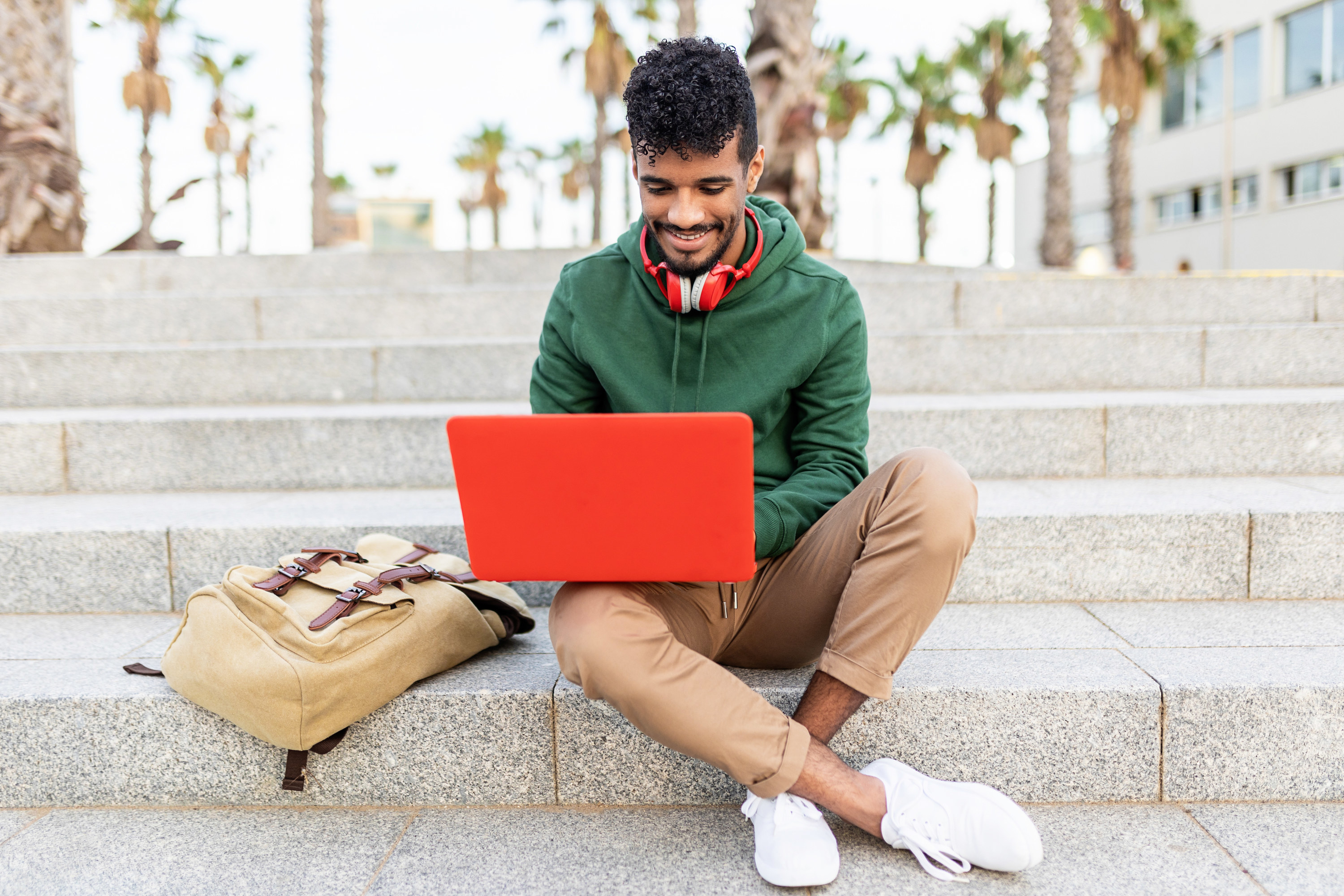 Man working on his laptop on the stairs