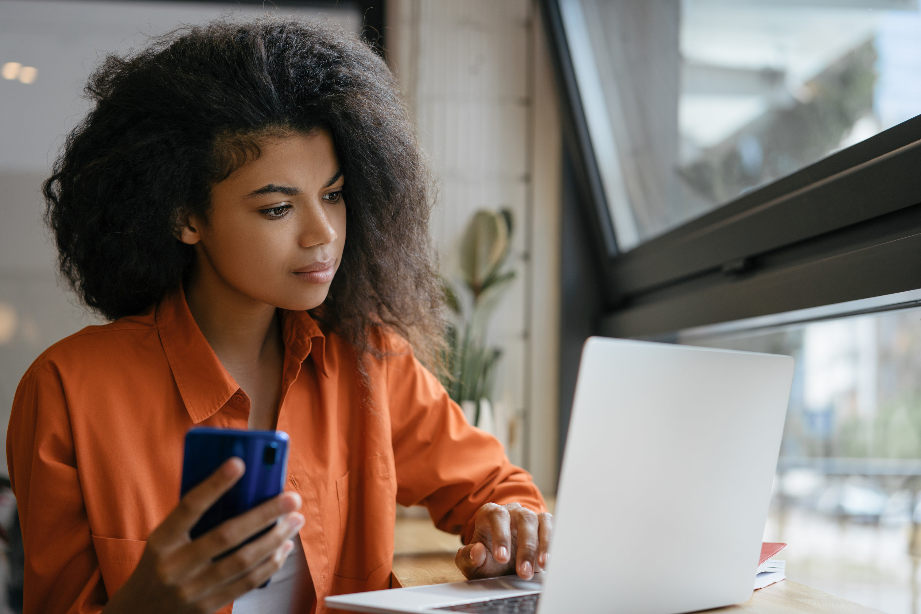 Woman looking at her computer and phone