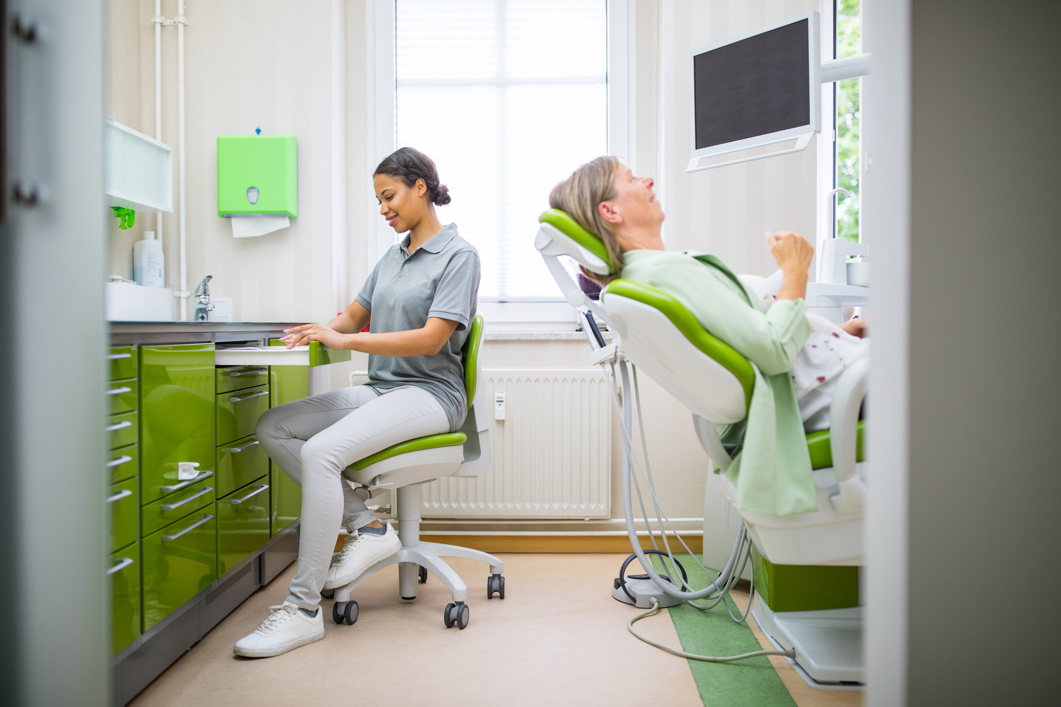 dental assistant in a chair with a woman ready for be examined