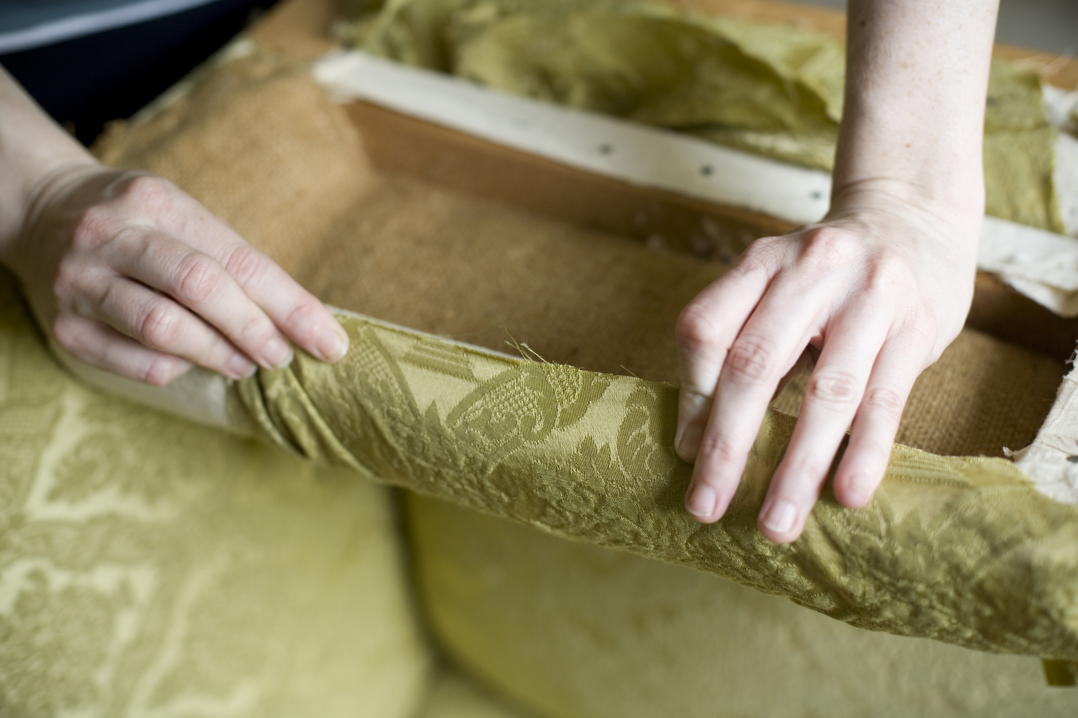 hands putting fabric over a wood