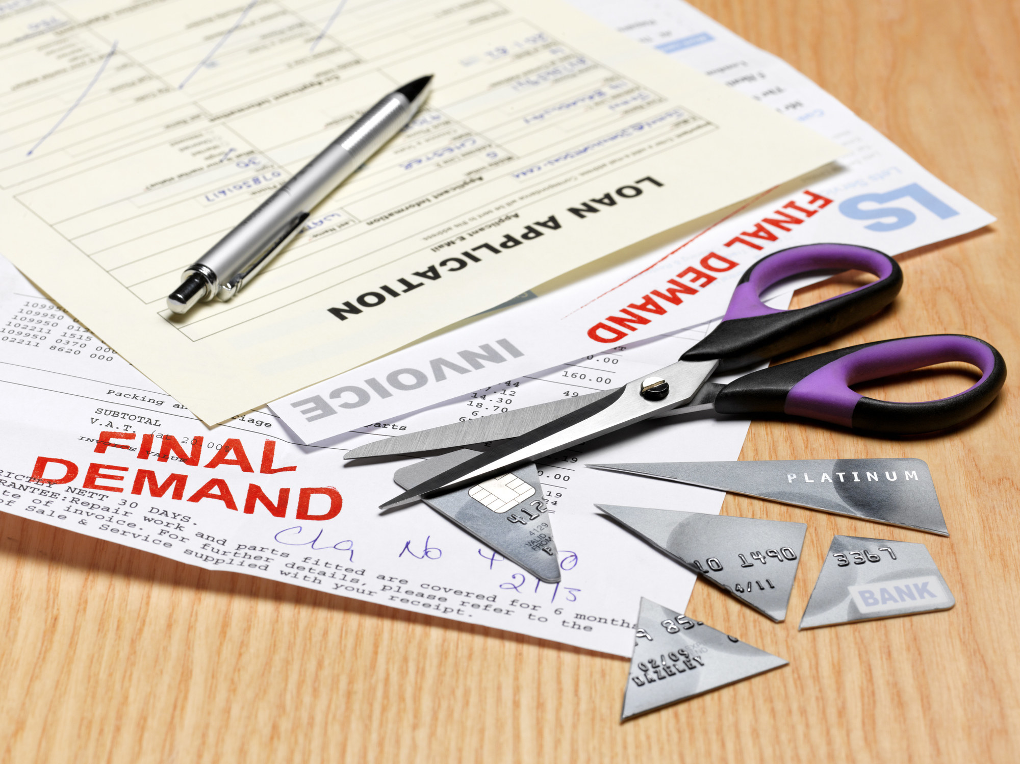 Financial papers and a cut-up credit card on a table