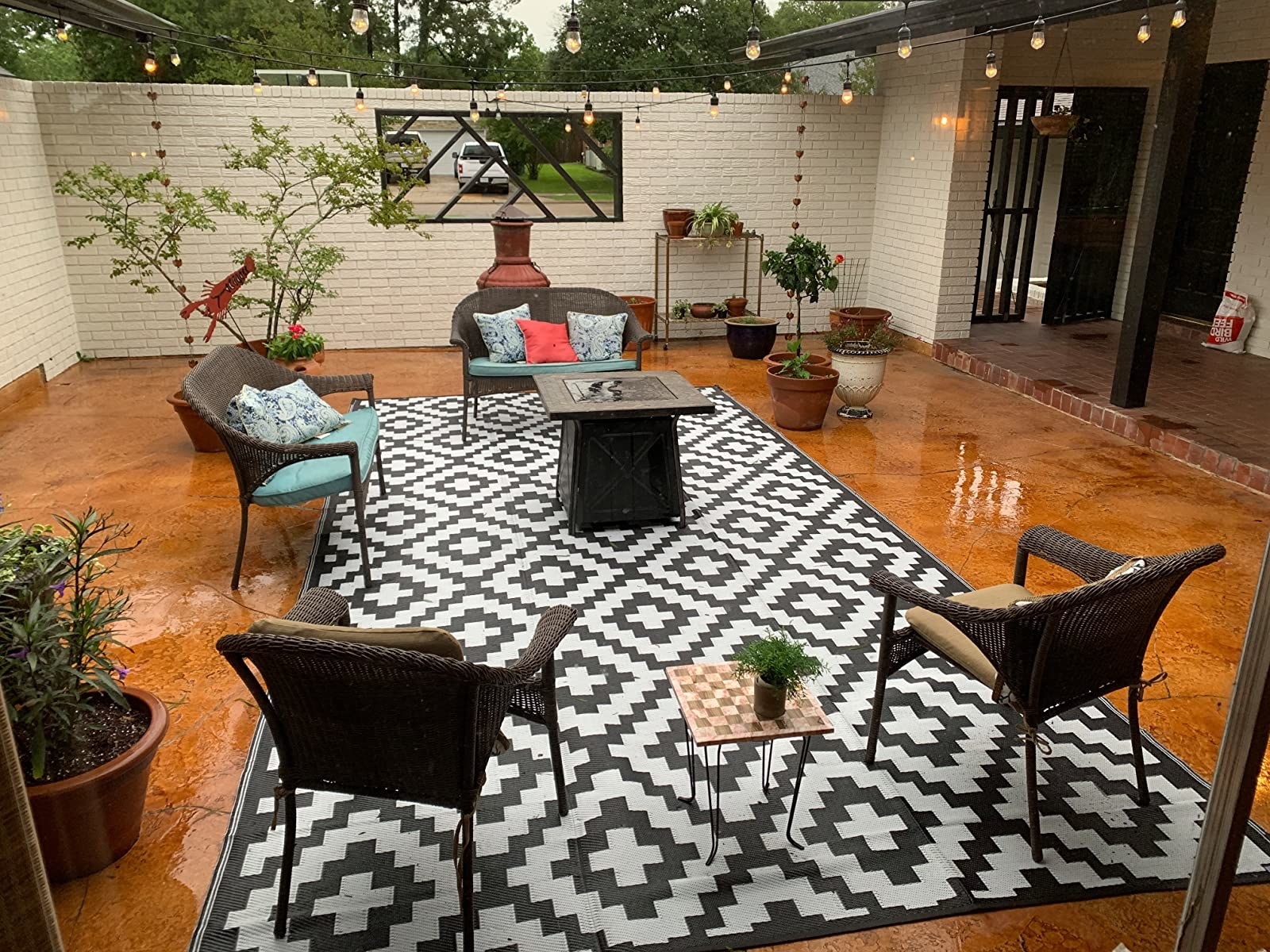 Reviewer&#x27;s outdoor rug is shown on a wet patio
