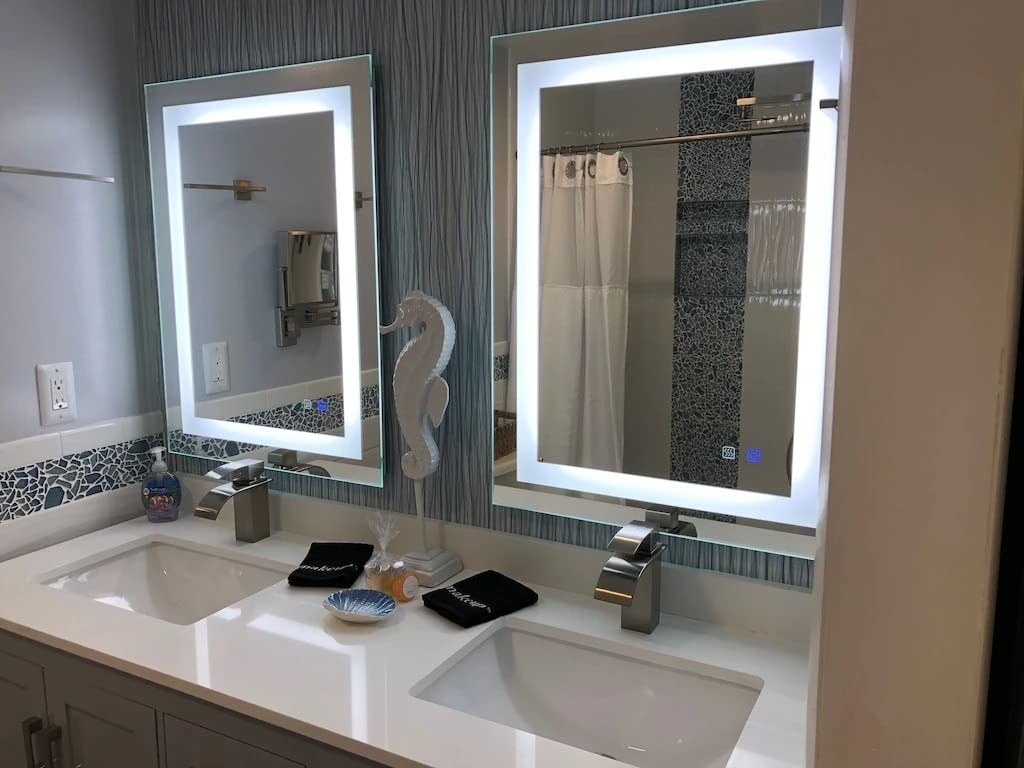 a review photo of two of the mirrors hanging above double sinks in a bathroom