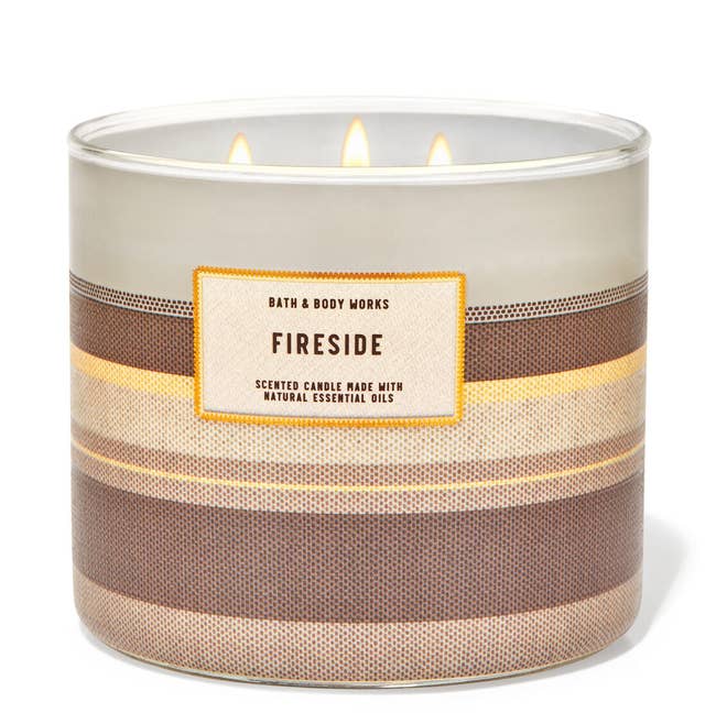 the candle in a scent called fireside with a brown and khaki neutral color container