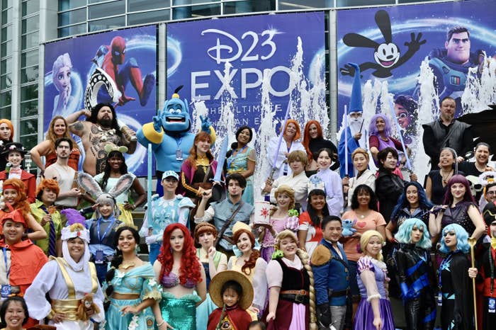A group of cosplayers assemble at the entrace of the D23 Fan Expo in 2022.
