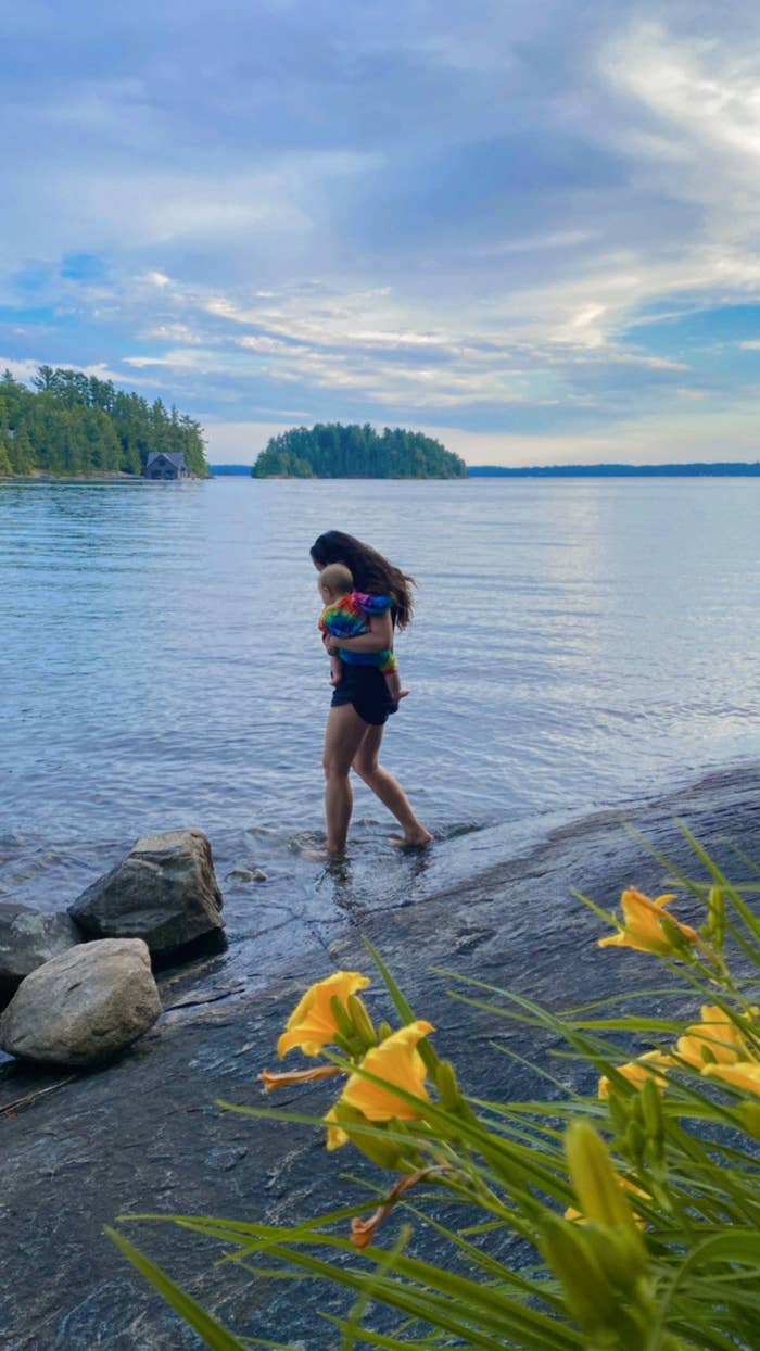 A mother and her baby wading in a lake