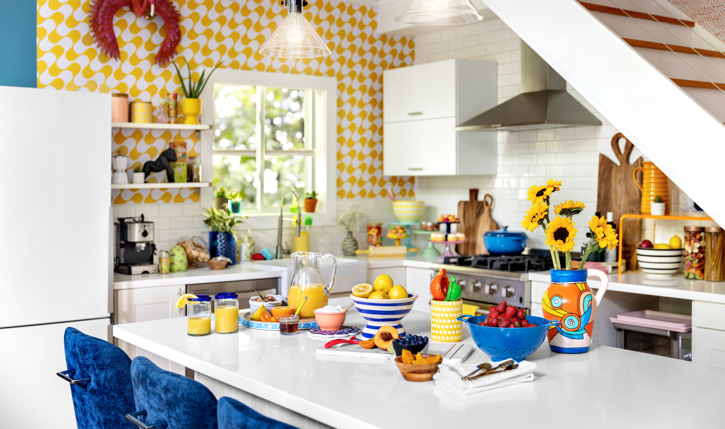 Kitchen with sunflowers, orange juice, lemons, and dishes on island