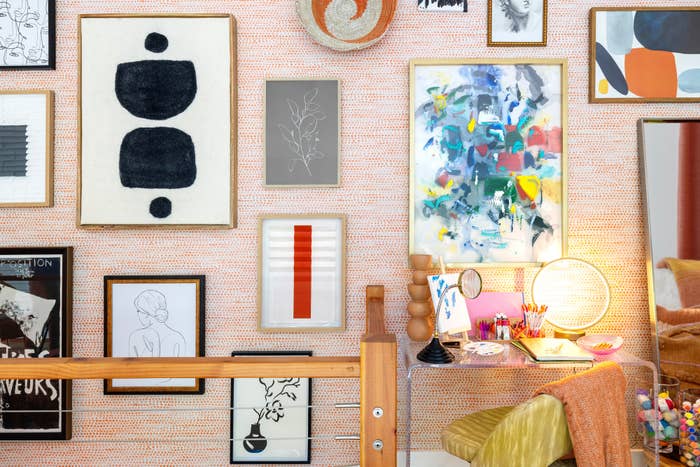 Wall art next to clear desk with decorative accessories on top