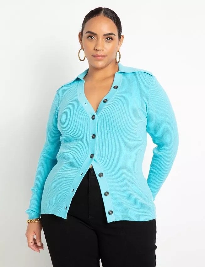 A model wearing a bright blue top and black pants