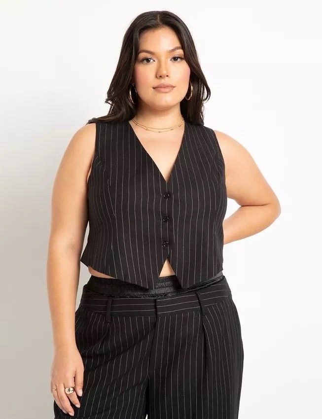 A model wearing a black and white pin stiped vest with matching pants