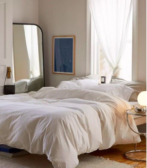 A bed with the white duvet cover on it