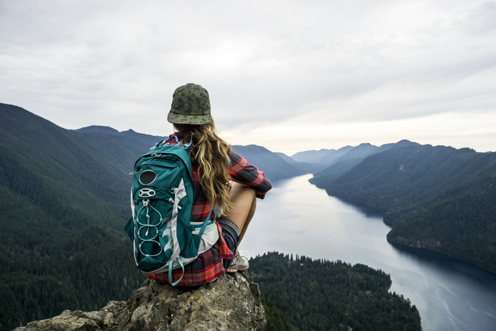 A female hiker looking out at a river