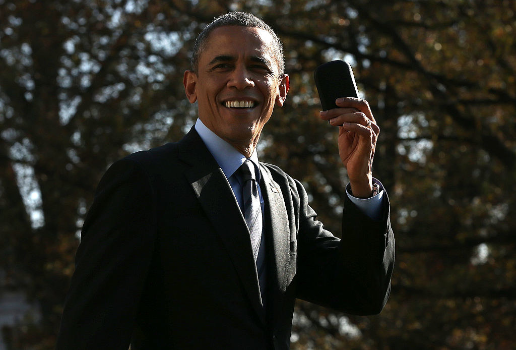 Barack Obama holding up his phone