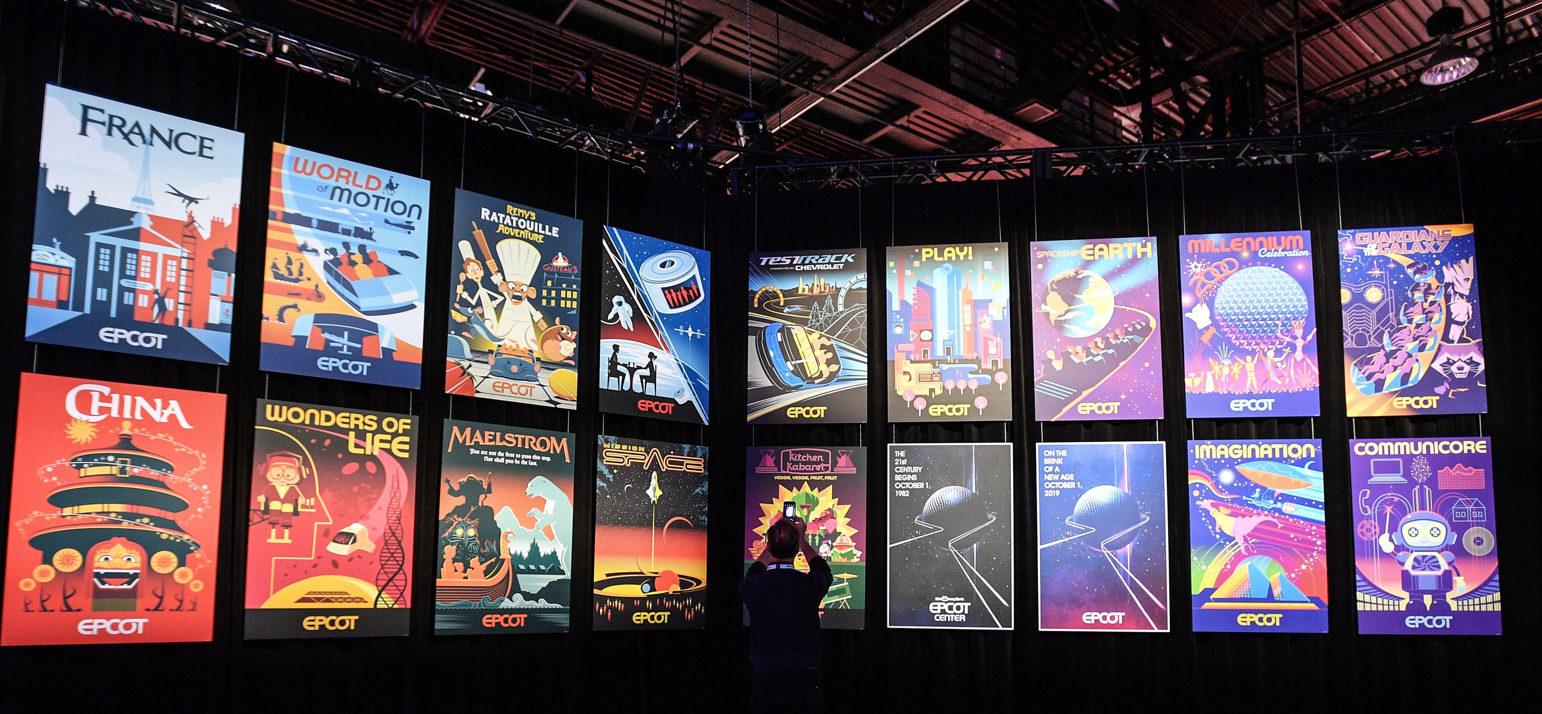 A visitor to the Epcot booth checks out retro-style posters during a media preview at the D23 Expo in 2019