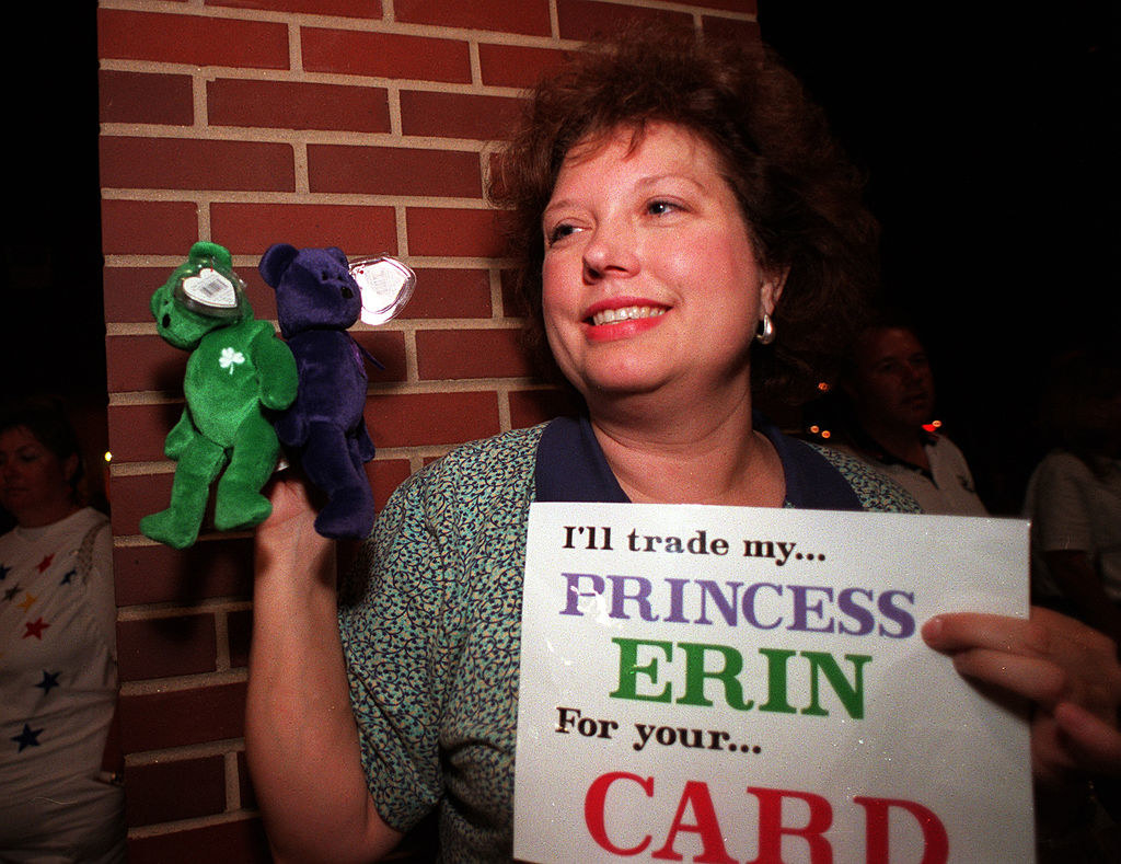 A woman holding Beanie Babies and a sign