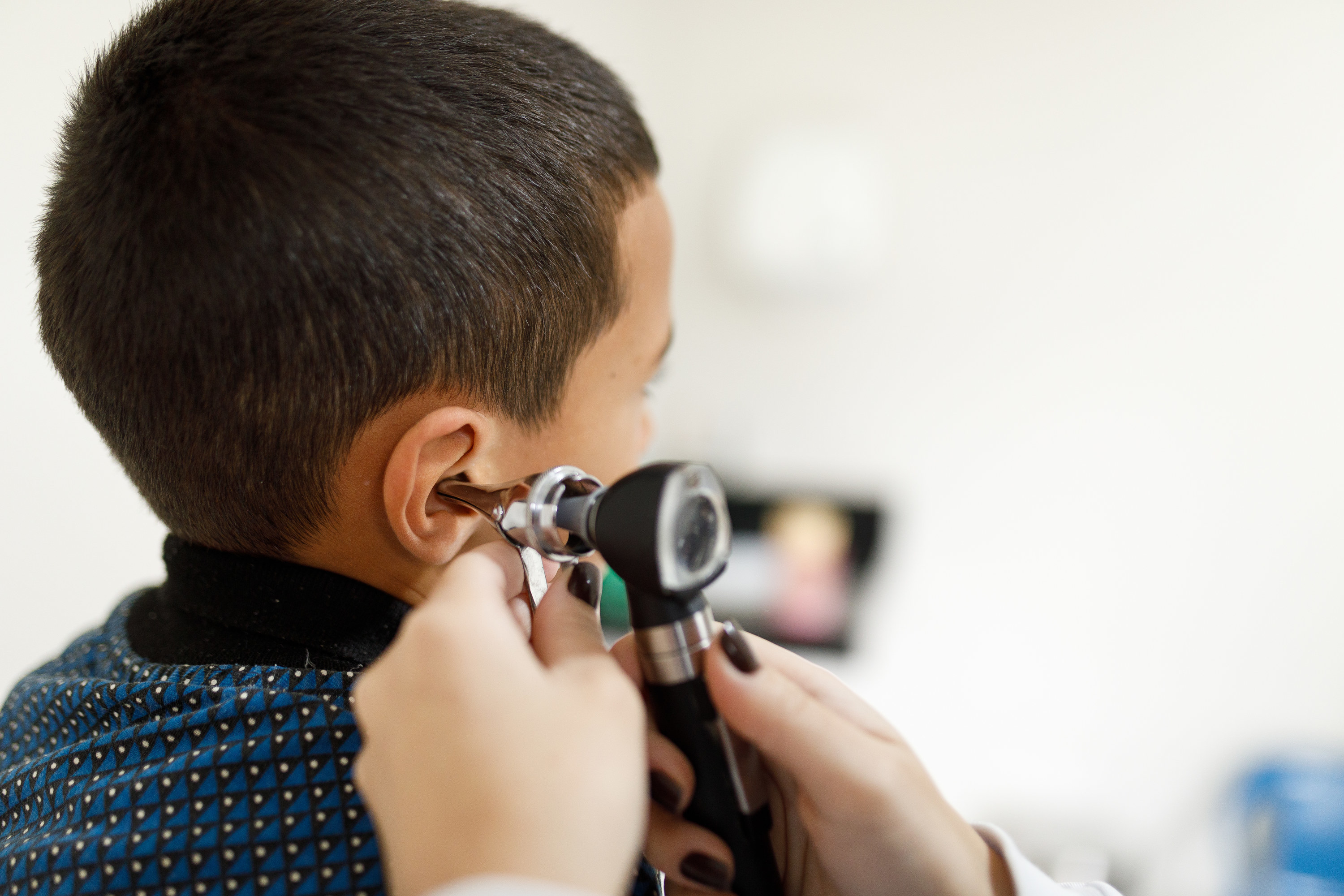 A doctor examining a kid&#x27;s ear