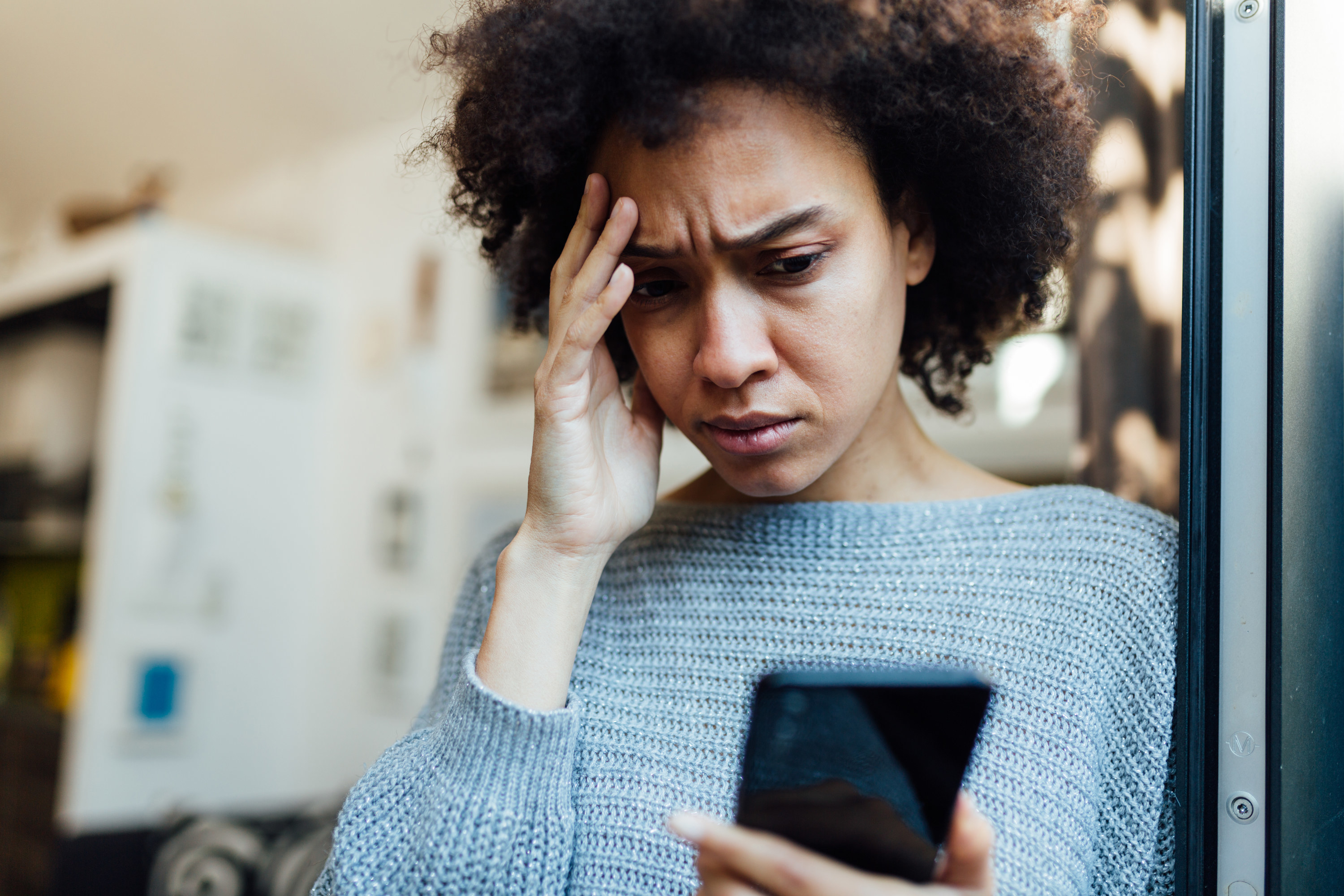 a woman looking at a phone, upset