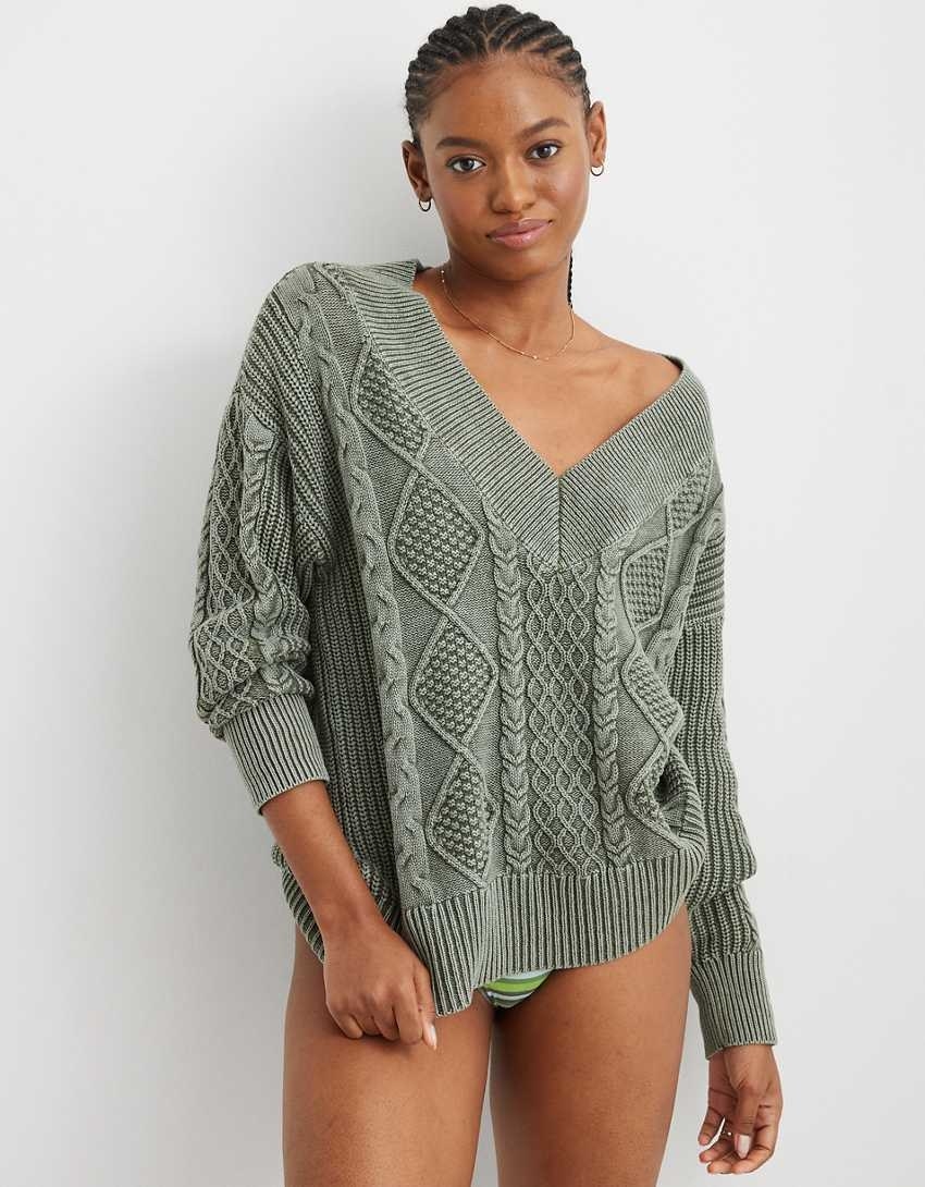 model in sage green v-neck sweater with varied kinds of cables