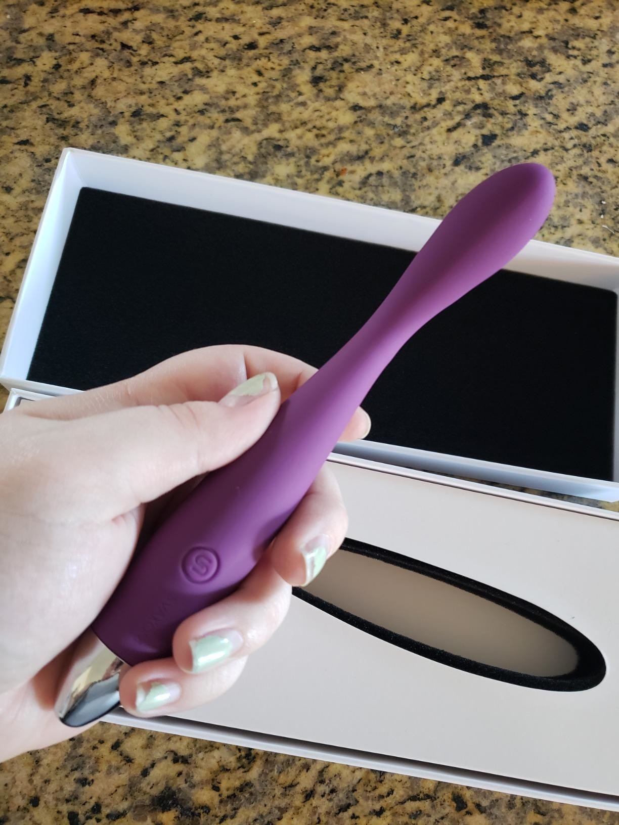 Reviewer holding slim purple vibrator