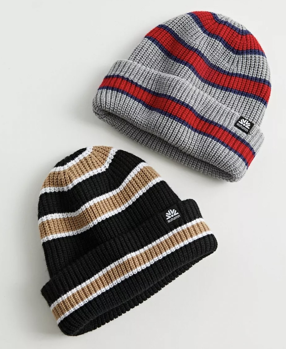 The black and gold beanie and the grey and red beanie