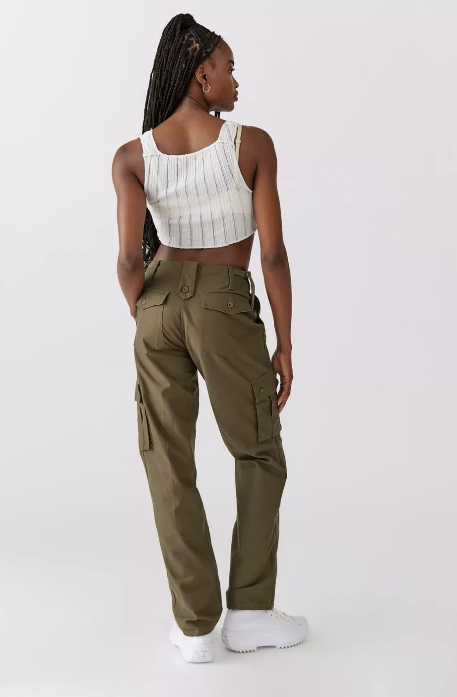 Model from behind in the green cargo pants, featuring lots of utility pockets on the side