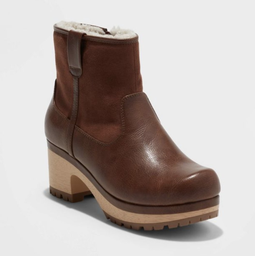 The thick dark brown boot has a tan sole and white fluffy insides