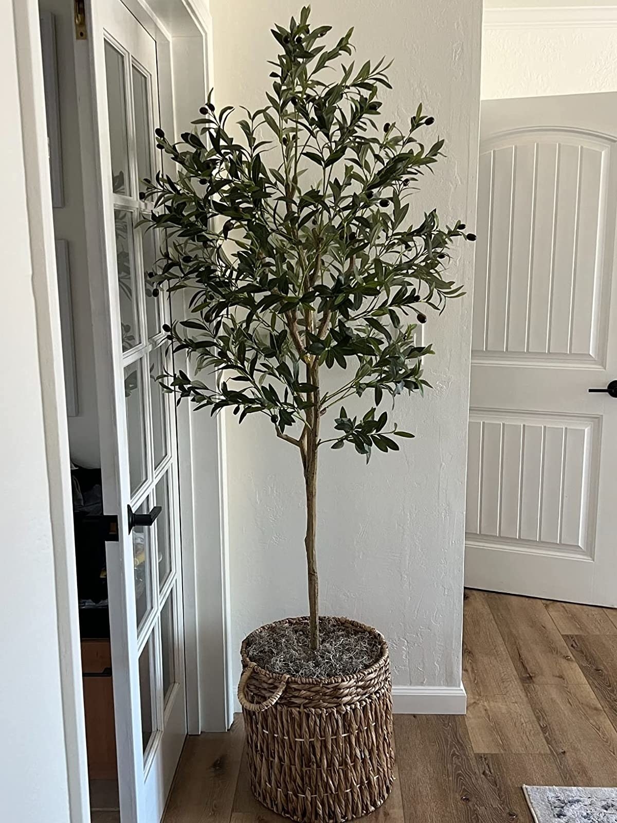 Reviewer&#x27;s faux olive tree is in a living room