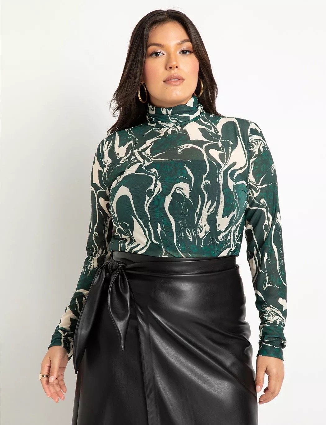 A green and white patterned top with a black leather skirt