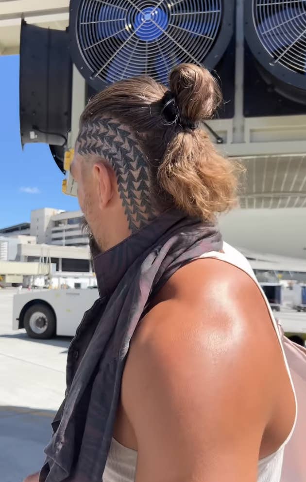 The tattoo features three columns of arrows on the side of his head running from the base of his neck&#x27;s, around his ear, to the top of his scalp