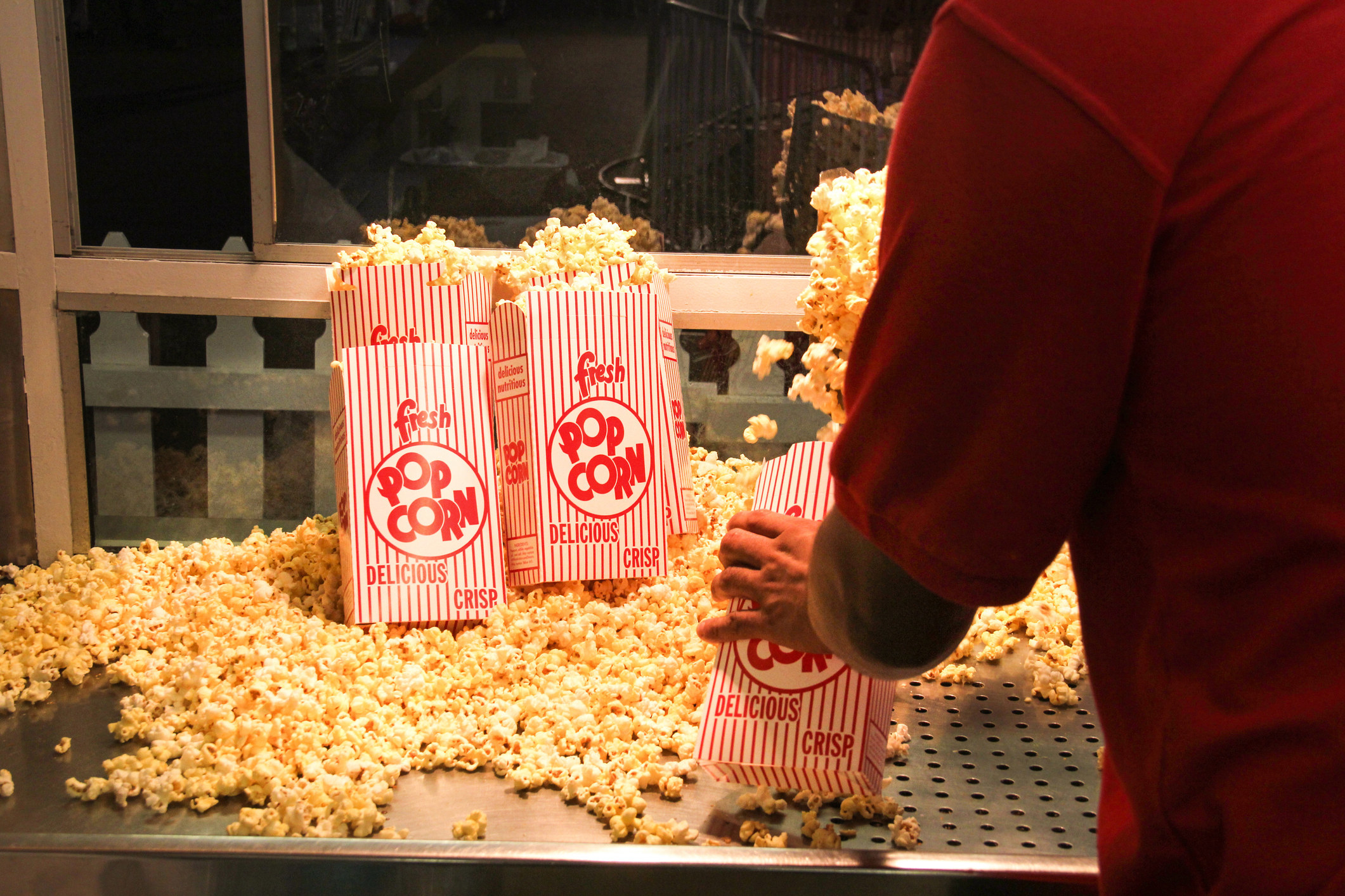 A person filling up bags of popcorn